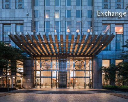 the entrance to an office building that has a large wooden pergolated canopy over it