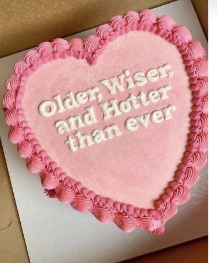 a heart shaped cake with the words older wise and hotter than ever on it