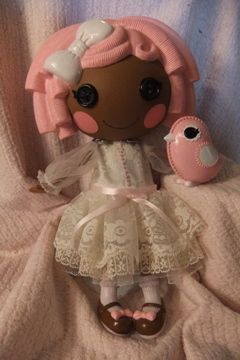 a small doll is sitting on a blanket