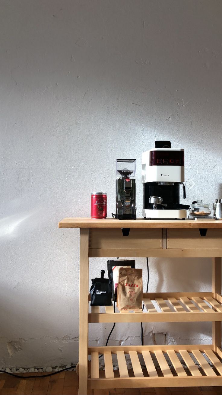 a wooden table topped with a microwave oven next to a toaster and coffee maker