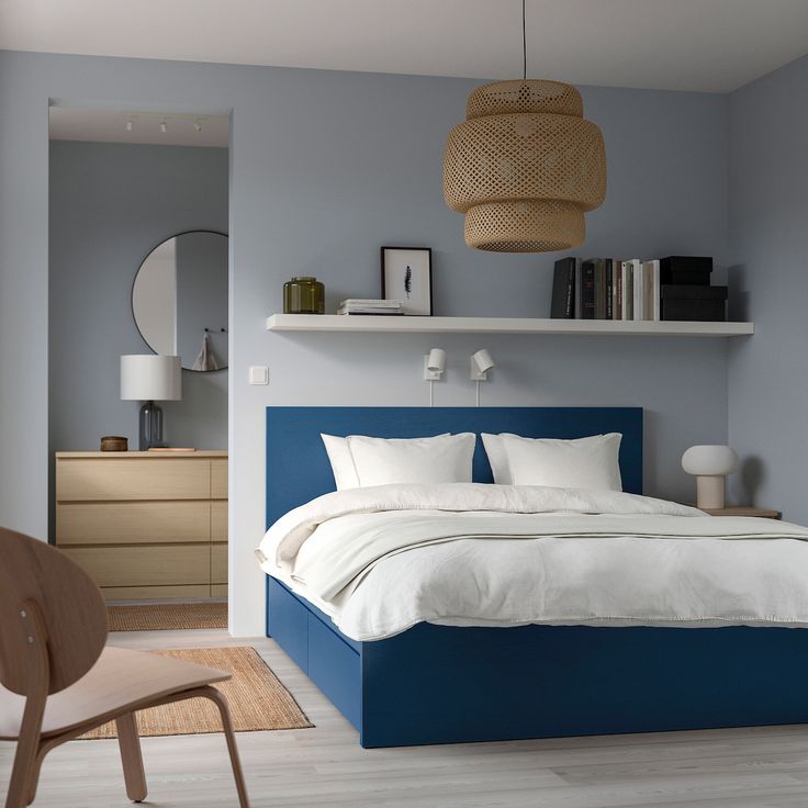 a bedroom with blue walls and white bedding