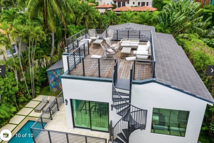 an aerial view of a house with stairs leading up to the roof and pool area