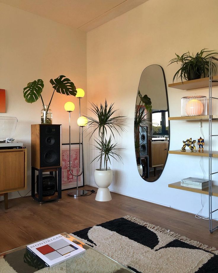 a living room filled with lots of plants next to a wall mounted speaker and speakers