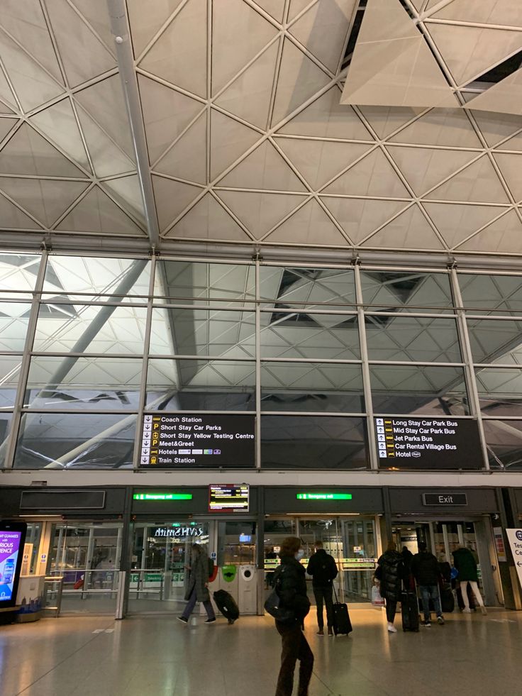 people are walking through an airport with their luggage