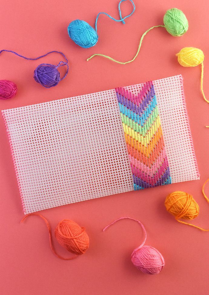 yarn and balls of thread laid out on a pink surface with a white piece of cloth