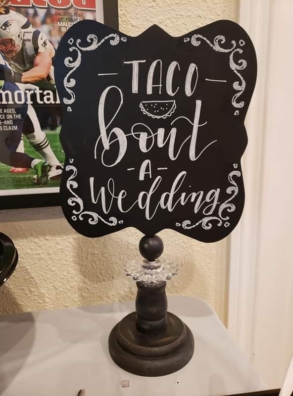 a chalkboard sign that says taco bout and wedding on top of a table