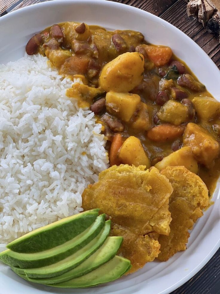 a white plate topped with rice, beans and avocado