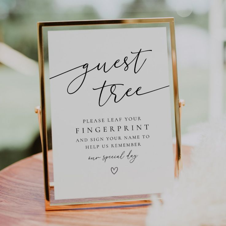 a sign that says guest tree on top of a wooden table next to a window