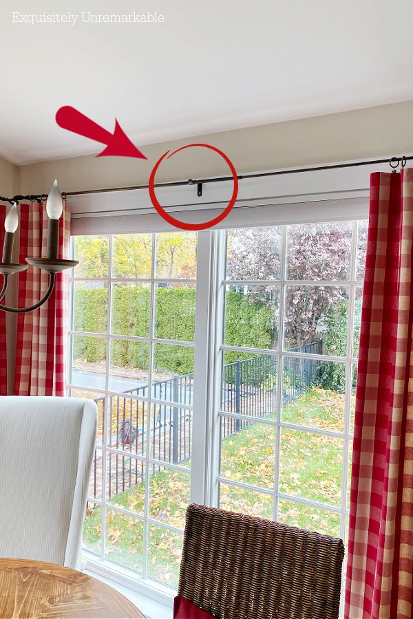 a red and white checkered curtain hanging in front of a dining room table with chairs