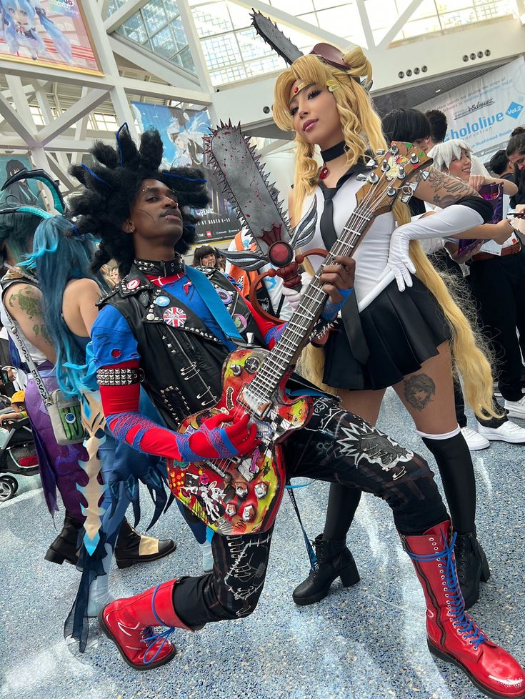 two women in costumes are posing with guitars