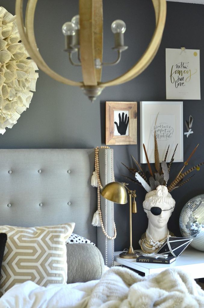 a bedroom with gray walls and gold accents