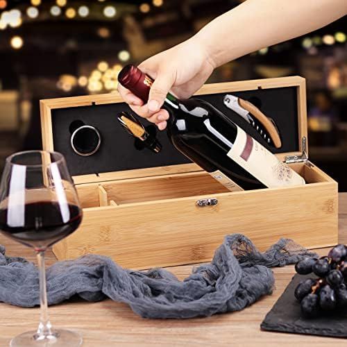 a person opening a bottle of wine in a wooden box next to a glass of red wine