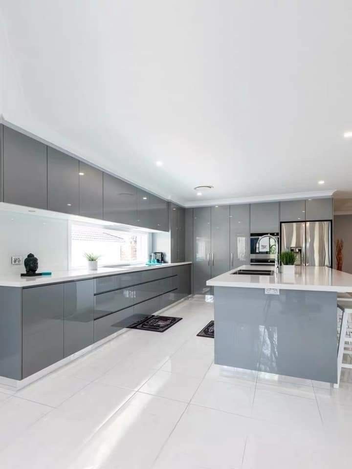 a large kitchen with white floors and gray cabinets