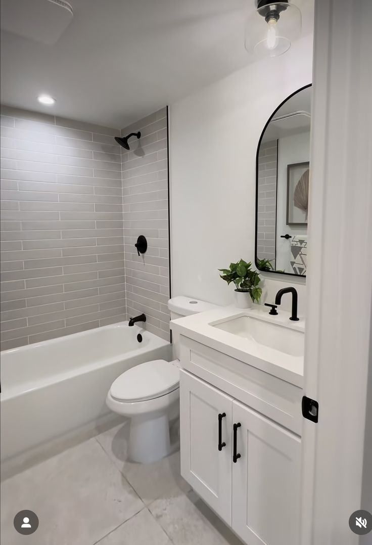 a white bathroom with a toilet, sink and bathtub is seen in this image