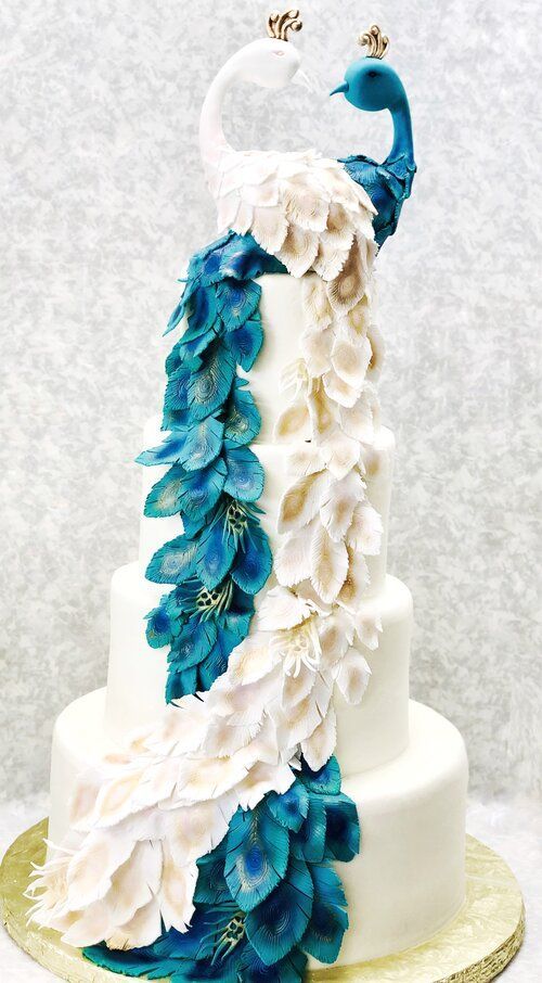 a white and blue wedding cake with feathers on it