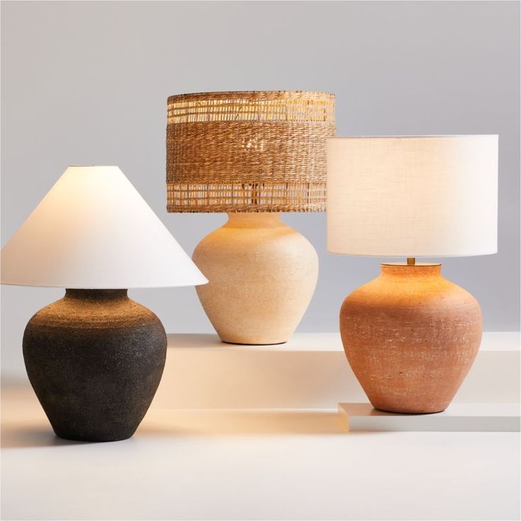 three different types of vases with lamps on the table next to each other,