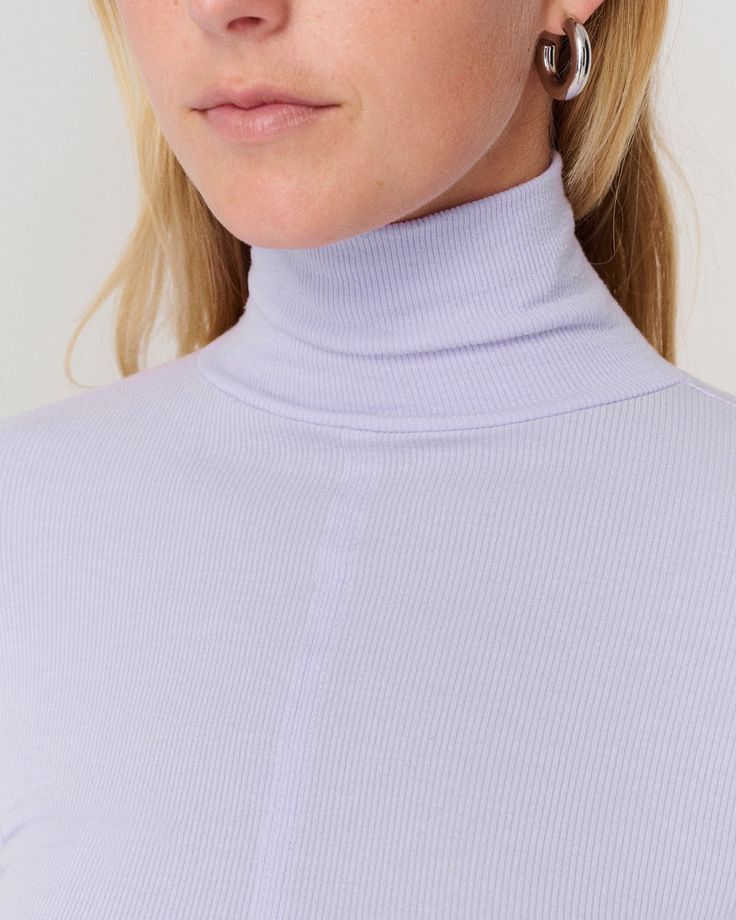 DETAILS: Color: Lavender Ribbed mock neck pullover Long sleeve Thumbholes at cuffs Design seam at front 95% Tencel, 5% Spandex Machine wash SIZE & FIT: Fits true to size Front length: 18" Bust: 13 3/4" Purple Ribbed Stretch Top, Purple Stretch Ribbed Tops, Stretch Purple Ribbed Tops, Stretch Ribbed Purple Tops, Lavender Top For Fall Layering, Lavender Top For Layering In Fall, Lavender Tops For Fall Layering, Purple Ribbed Top, Spring Turtleneck Top With Ribbed Cuffs