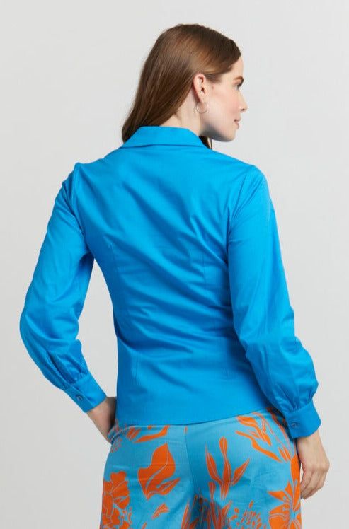 The US Sizes are an estimate; we recommend using the Size Guide for your measurements. Be the perfect fashionista in this Capri Blue Ruched Button Up Cotton Blouse. The stunning sky blue color is accented by the ruched button-up bodice and collared neckline, creating a timeless style that flatters the waistline. Breathable, lightweight and comfortable, this cotton blouse pairs perfectly with dress pants or jeans. Look amazing and feel confident with this must-have blouse! Made in Italy by EnhleC Blue Collared Blouse For Spring, Blue Collar Blouse For Daywear, Blue Collared Blouse For Work, Blue Cotton Blouse With Button Cuffs, Blue Tops With Button Cuffs For Work, Blue Spread Collar Blouse For Daywear, Blue Cotton Office Blouse, Fitted Collared Blouse In Light Blue, Fitted Blue Blouse With Collared Neckline