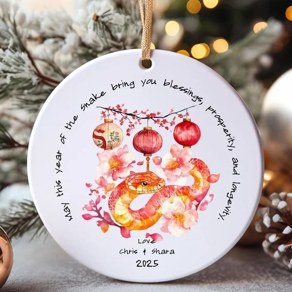 a christmas ornament hanging from a tree with ornaments around it and the words happy new year