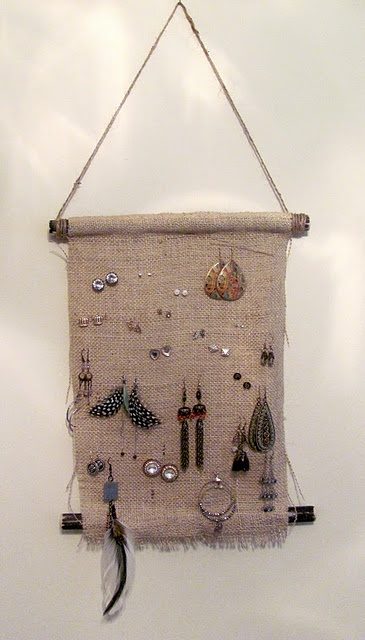 a wall hanging with earrings and other items on it's back looped together