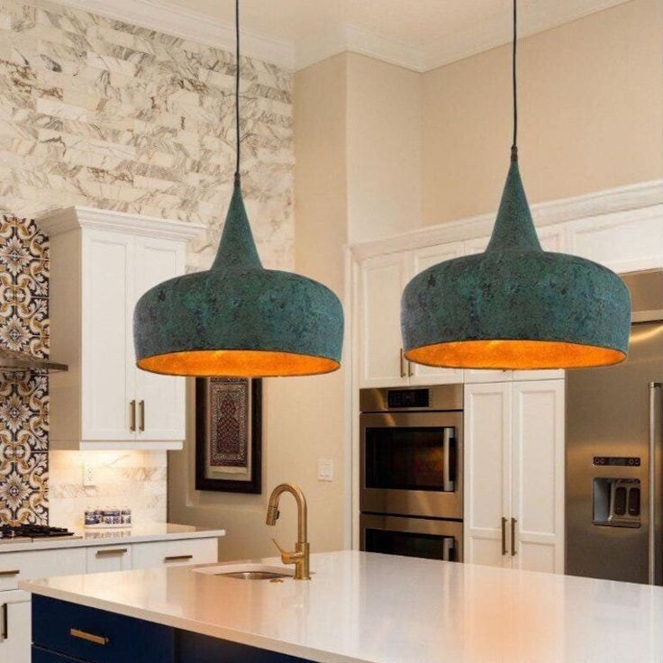 two pendant lights hanging over a kitchen island