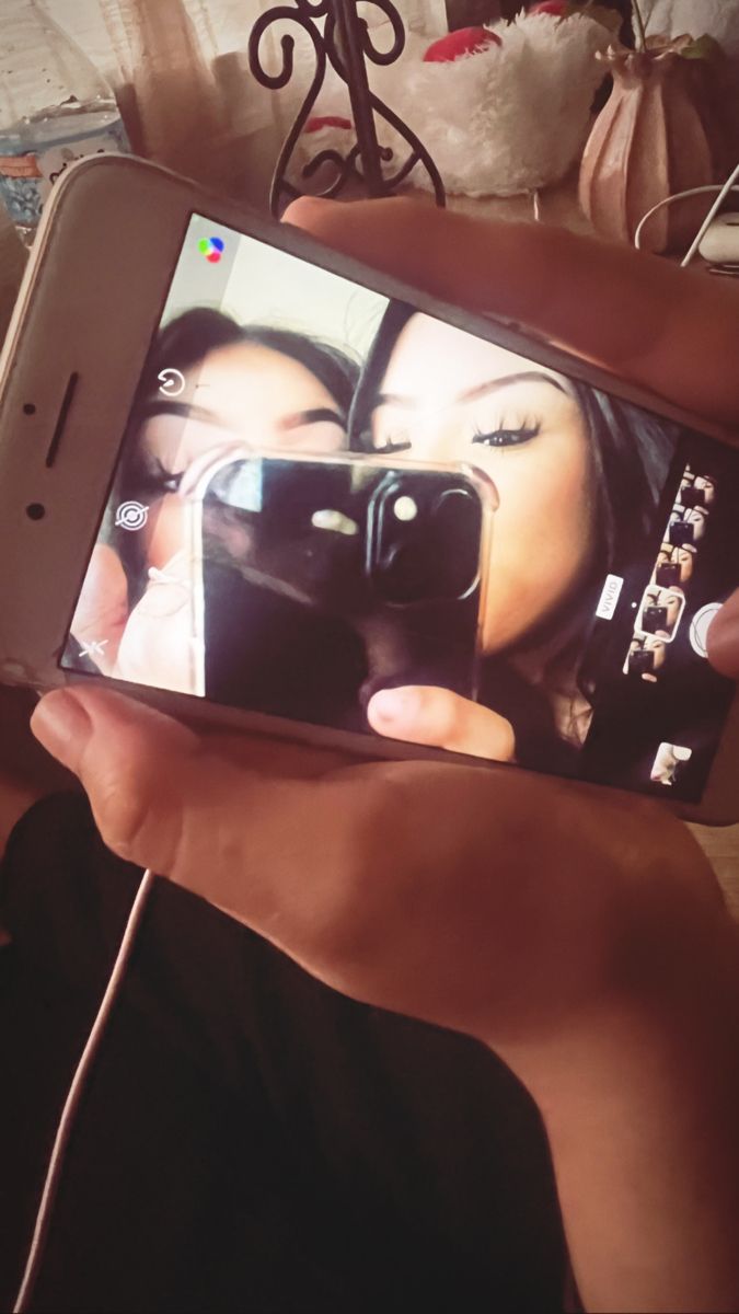 a person holding up a cell phone to take a selfie with her face on the screen