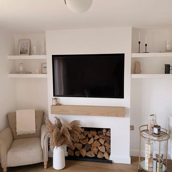 a flat screen tv mounted on the wall above a fire place in a living room