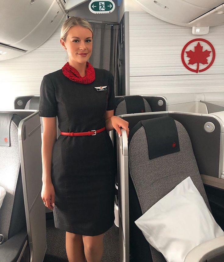 a woman standing on an airplane with her luggage