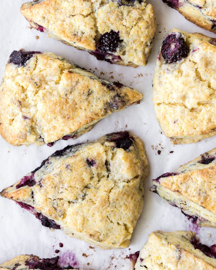 blueberry scones are arranged on a piece of parchment paper and ready to be eaten