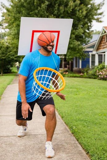 a man with a basketball hoop on his head is holding a frisbee in front of him