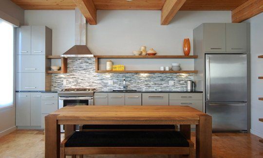 a modern kitchen with stainless steel appliances and wood beams on the ceiling, along with open shelving