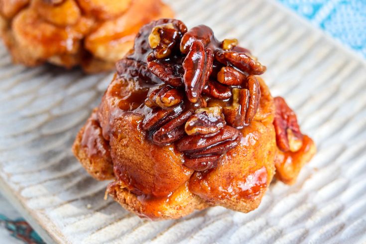 two pastries with pecans on top sit on a plate