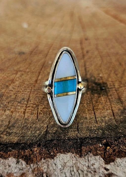 Sterling silver with mother of pearl and turquoise inlay. 14k gold embellishments. Size: 5.5 Elegant Turquoise Inlay Rings, Bohemian Turquoise Inlay Ring For Anniversary, Bohemian Turquoise Ring With Inlay For Anniversary, Unique Turquoise Inlay Ring, White Sterling Silver Rings With Inlay, White Sterling Silver Ring With Inlay, Sterling Silver White Inlay Ring, White Sterling Silver Jewelry With Inlay, Sterling Silver Jewelry With White Inlay