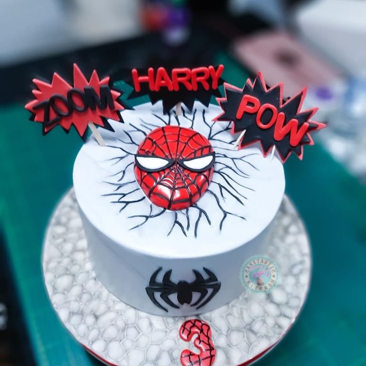 a spiderman birthday cake with the words happy pow on it's top tier