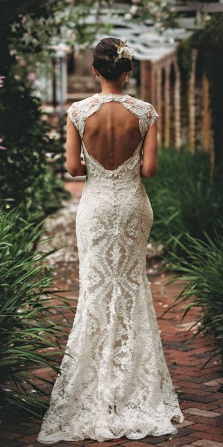 a woman in a wedding dress is walking down the path with her back to the camera