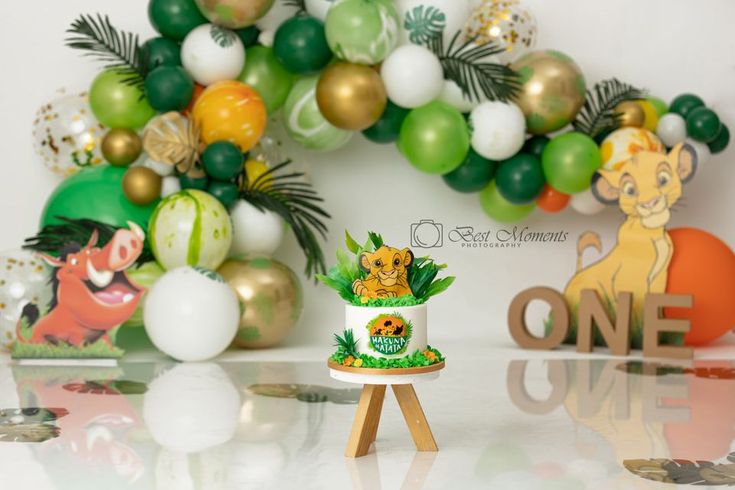 a cake sitting on top of a wooden tripod in front of a jungle theme