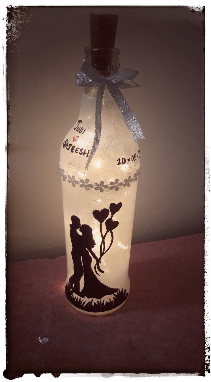 a lighted bottle with a silhouette of a man and woman on it