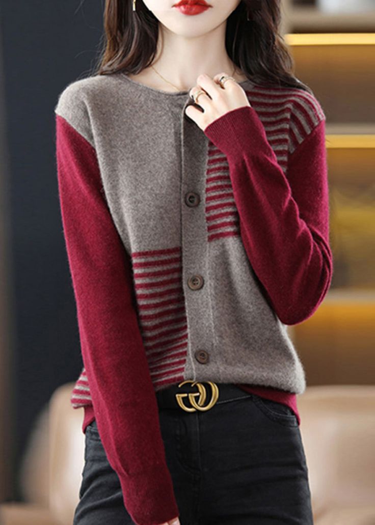 a woman wearing black pants and a red cardigan sweater is posing for the camera