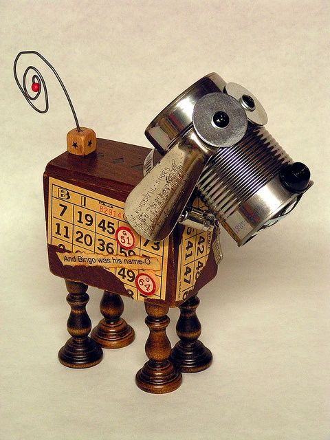 a toy dog made out of an old clock and some sort of tin canister