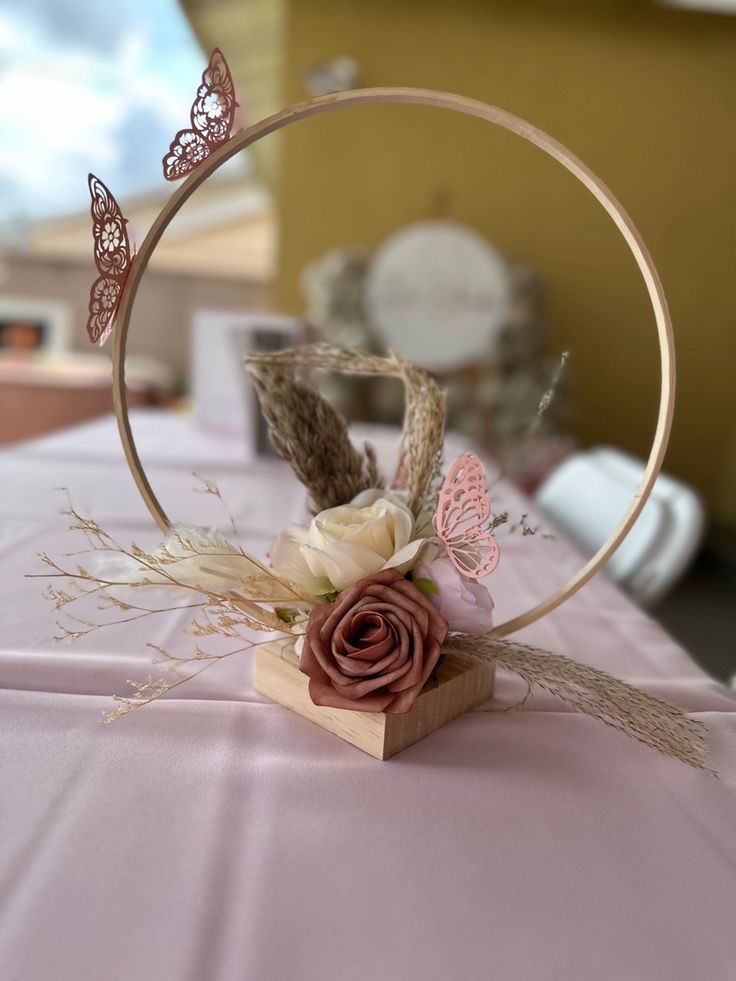 a close up of a head piece on a table with flowers and butterflies in it