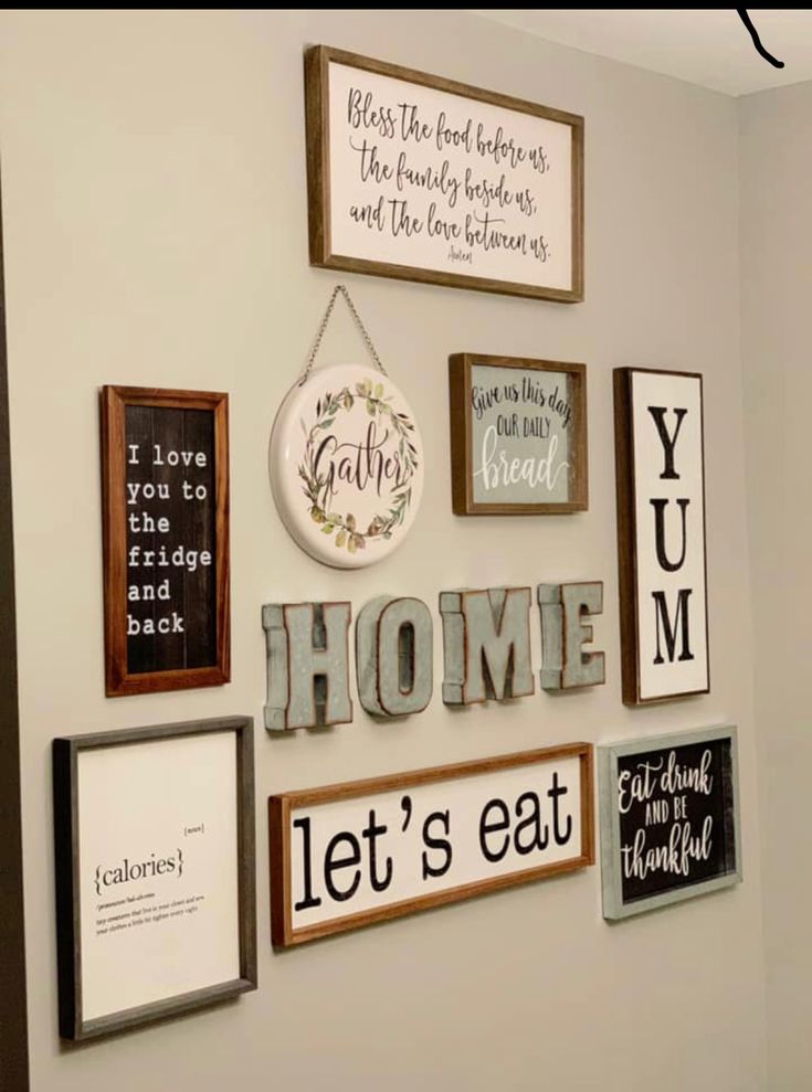 a wall with various framed pictures and signs on it's side, including the words home let's eat