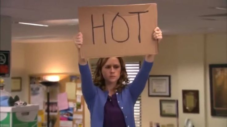 a woman holding up a sign that says hot