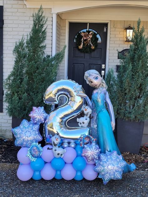 a frozen princess birthday party with balloons and decorations for the number two on display in front of a house