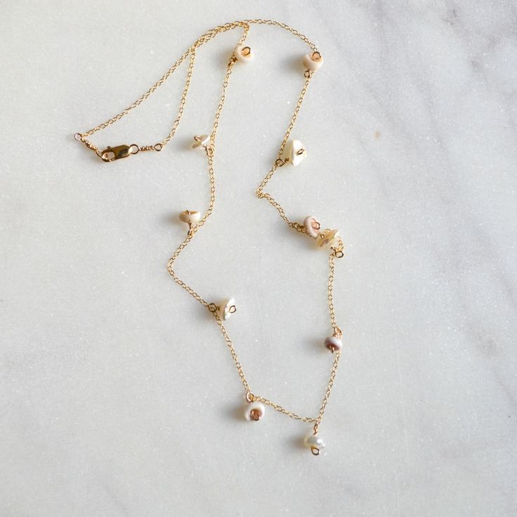 Dainty little puka shells and keshi white pearls dangle from a delicate 1.1mm 14k gold filled cable chain. Dainty Pearl Charm Necklace In 14k Gold, White 14k Gold Charm Necklace With Delicate Chain, Dainty 14k Gold Necklace With Pearl Charm, Dainty 14k Gold Filled Charm Necklace With Pearl Pendant, Delicate 14k Gold Filled Briolette Necklace, Delicate 14k Gold Filled Charm Necklaces With Pearl Pendant, Delicate 14k Gold Filled Necklaces With Pearl Charm, Delicate 14k Gold-filled Charm Necklace With Pearl Pendant, Delicate 14k Gold-filled Necklace With Pearl Charm