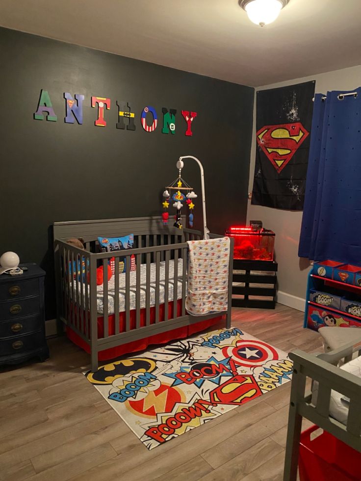 a child's room with superman themed decor and toys on the floor, including a crib