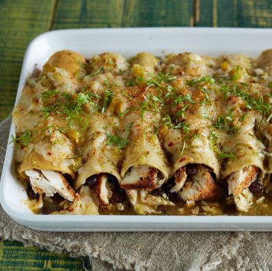 a casserole dish filled with meat, cheese and sauce on a table cloth