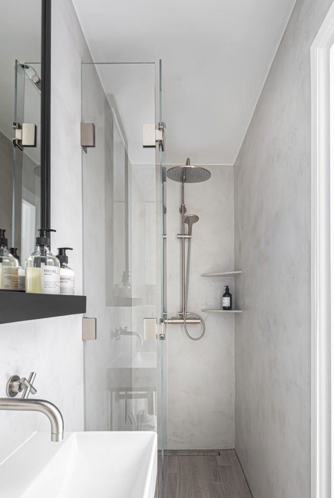 a bathroom with a sink, mirror and shower head in it's center wall