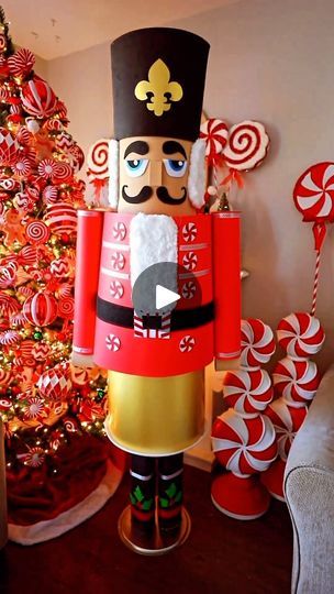 a large nutcracker standing in front of a christmas tree with candy canes