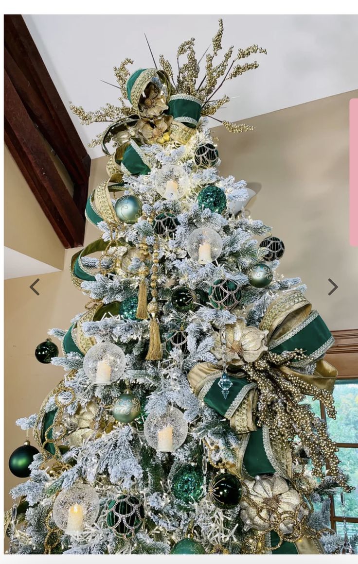 a white christmas tree with green and gold decorations