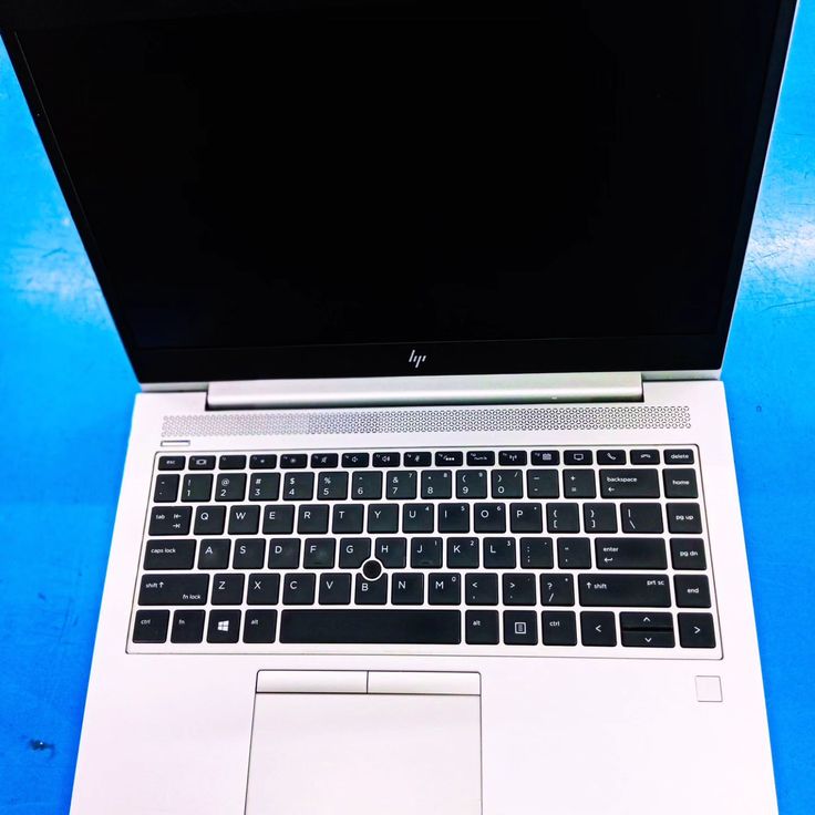 an open laptop computer sitting on top of a blue table